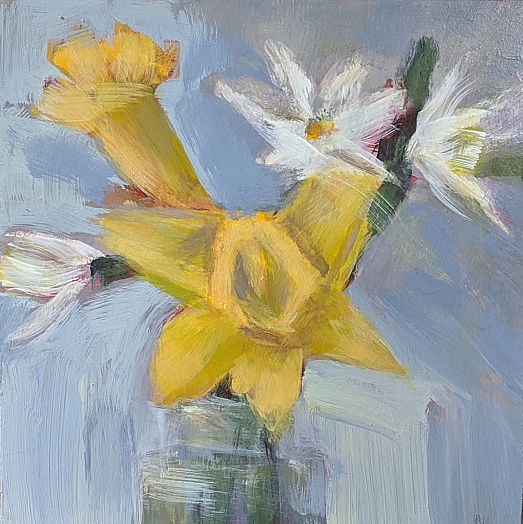 two yellow daffodils in vase with little white floweres